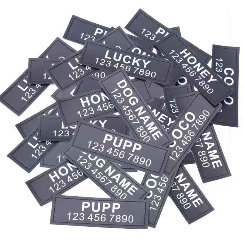 A pile of personalised Waggy Tails name tags printed with different dog names and phone numbers